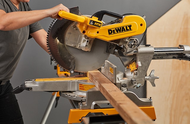 Person using a mitre saw to cut wood