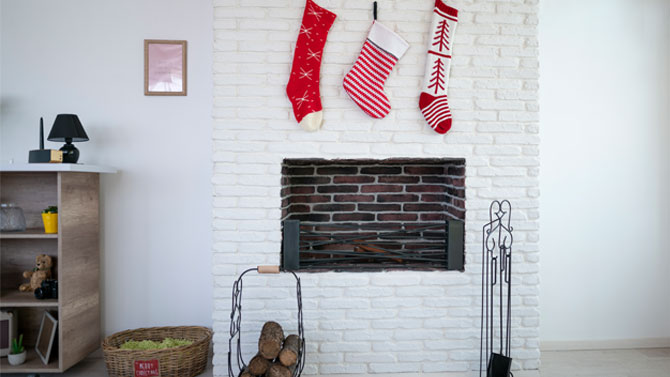 white painted brick fireplace with red stockings